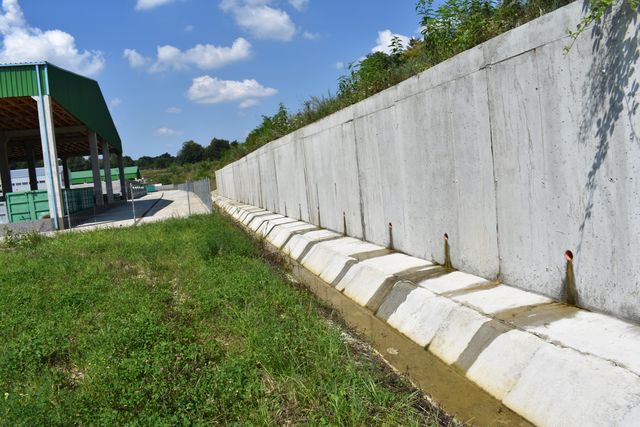 Zid lung de beton cu barbacane la baza lui și rigolă de beton
